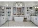 Luxurious bathroom featuring a freestanding tub, chandelier, and custom built-in shelving at 2527 E Beechnut Ct, Chandler, AZ 85249