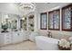 Elegant bathroom with a soaking tub, dual sinks, and custom built-in shelving at 2527 E Beechnut Ct, Chandler, AZ 85249