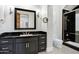 Bathroom featuring a black vanity, tile floors, black shower with glass doors, and modern lighting at 2527 E Beechnut Ct, Chandler, AZ 85249