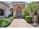 Welcoming front entrance showcasing a wrought iron door, stone accents, and lush landscaping at 2527 E Beechnut Ct, Chandler, AZ 85249