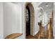 Unique hallway featuring stone archways, a decorative iron gate, and hardwood floors, showcasing architectural elegance at 2527 E Beechnut Ct, Chandler, AZ 85249