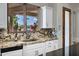 Bright kitchen with granite countertops, white cabinetry, and view of the lush backyard at 2527 E Beechnut Ct, Chandler, AZ 85249