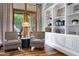 Charming living room area with armchairs, hardwood floors, and natural light through wood frame windows at 2527 E Beechnut Ct, Chandler, AZ 85249