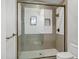 Close-up of shower with glass door, beige tile walls, and a built-in niche for toiletries at 2527 E Beechnut Ct, Chandler, AZ 85249