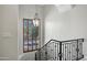 Staircase with black wrought iron railing and shuttered window with hanging light fixture at 2527 E Beechnut Ct, Chandler, AZ 85249