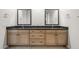 Bathroom with a double sink vanity, black countertop, and two decorative mirrors at 26139 S 225Th Way, Queen Creek, AZ 85142