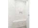 Modern shower with white marble tile and a built-in bench and storage niche at 26139 S 225Th Way, Queen Creek, AZ 85142