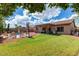 Large grassy backyard featuring a covered patio, lounge chairs and mature green trees at 2685 N 132Nd Dr, Goodyear, AZ 85395