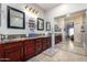 Bathroom featuring double vanity, large mirror, and glass shower at 2685 N 132Nd Dr, Goodyear, AZ 85395