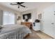 Bedroom with a large TV, ceiling fan and tile flooring adjacent to the carpeted space at 2685 N 132Nd Dr, Goodyear, AZ 85395
