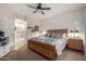 Bedroom features a comfortable bed, neutral decor, a ceiling fan, and adjacent bathroom entrance at 2685 N 132Nd Dr, Goodyear, AZ 85395