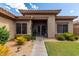 Inviting front entrance featuring a covered porch, desert landscaping, and a freshly manicured green lawn at 2685 N 132Nd Dr, Goodyear, AZ 85395