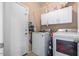 Functional laundry room with washer, dryer, storage cabinets and access to the outdoors at 2685 N 132Nd Dr, Goodyear, AZ 85395