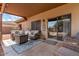 Enjoy outdoor living on this covered patio with comfortable seating, rug and decor at 2685 N 132Nd Dr, Goodyear, AZ 85395