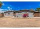 View of the house showing the backyard, with flowering shrub, windows and fencing at 3013 W Port Au Prince Ln, Phoenix, AZ 85053