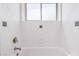 This bathroom features white tiles, a showerhead, a frosted glass window, and a bathtub at 3013 W Port Au Prince Ln, Phoenix, AZ 85053