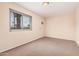 This bedroom includes a window, carpet flooring, beige walls, and an AC unit at 3013 W Port Au Prince Ln, Phoenix, AZ 85053