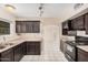 Well lit kitchen featuring tile flooring, modern appliances, and dark wood cabinetry at 3013 W Port Au Prince Ln, Phoenix, AZ 85053