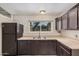 Efficient kitchen featuring dark cabinetry, stainless steel sink, and window views at 3013 W Port Au Prince Ln, Phoenix, AZ 85053