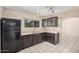 Well lit kitchen featuring tile flooring, modern appliances, and dark wood cabinetry at 3013 W Port Au Prince Ln, Phoenix, AZ 85053