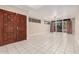 A bright, spacious living room with tile flooring, abundant natural light, and double front doors at 3013 W Port Au Prince Ln, Phoenix, AZ 85053