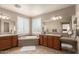 Bright bathroom featuring dual sinks, tile flooring, soaking tub, and shutters on the windows at 3308 E Jasper Dr, Gilbert, AZ 85296