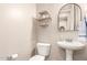Charming powder room featuring a pedestal sink, decorative mirror, and stylish shelving at 3308 E Jasper Dr, Gilbert, AZ 85296