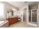 Bathroom featuring dual sinks, tiled shower, and an attached vanity area with a stool at 3308 E Jasper Dr, Gilbert, AZ 85296