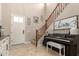 Inviting foyer with tile flooring, staircase with wood railings, a piano and a stylish front door at 3308 E Jasper Dr, Gilbert, AZ 85296