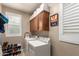 Functional laundry room with appliances, cabinet storage, a window and shoe storage at 3308 E Jasper Dr, Gilbert, AZ 85296