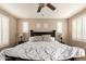 Comfortable main bedroom featuring neutral walls, white shutters, ceiling fan, and decorative pillows at 3308 E Jasper Dr, Gilbert, AZ 85296
