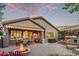 Backyard with covered patio and stone fireplace, perfect for outdoor living and entertaining guests at 343 W Twin Peaks Pkwy, San Tan Valley, AZ 85143