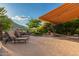 Beautiful backyard with a covered patio, lounge chairs, fire pit, BBQ and mature landscaping at 343 W Twin Peaks Pkwy, San Tan Valley, AZ 85143