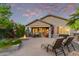 Serene backyard featuring covered patio, fire pit, mature landscaping, and relaxing lounge chairs at 343 W Twin Peaks Pkwy, San Tan Valley, AZ 85143