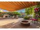 Spacious backyard featuring mature landscaping, a fire pit, fireplace, lounge chairs and a covered patio at 343 W Twin Peaks Pkwy, San Tan Valley, AZ 85143