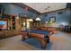 Relaxing game room with two billiard tables, wooden trim and cabinetry, and elegant lighting fixtures at 343 W Twin Peaks Pkwy, San Tan Valley, AZ 85143