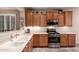 Kitchen featuring stainless steel appliances, light countertops, tile floors, and medium wood cabinets at 343 W Twin Peaks Pkwy, San Tan Valley, AZ 85143