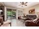 Comfortable living room with a ceiling fan, plush leather seating, and a view of the outdoor patio at 343 W Twin Peaks Pkwy, San Tan Valley, AZ 85143