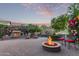 Inviting backyard with a cozy fire pit, a stone fireplace, patio furniture, and beautiful desert landscape at 343 W Twin Peaks Pkwy, San Tan Valley, AZ 85143