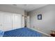 This is a gray bedroom featuring a double door closet and blue patterned bedspread at 3515 N Brooklyn Dr, Buckeye, AZ 85396