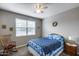 Cozy bedroom with a rocking chair, blue patterned bedding, and a ceiling fan at 3515 N Brooklyn Dr, Buckeye, AZ 85396