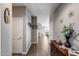 Long hallway featuring wood-look tile, neutral paint, and artful decor leading to the living area at 3515 N Brooklyn Dr, Buckeye, AZ 85396