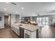 Spacious kitchen with a large granite island and stainless steel appliances that opens to living space at 3515 N Brooklyn Dr, Buckeye, AZ 85396