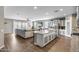Open-concept kitchen and living area features a large island, granite countertops, and stainless steel appliances at 3515 N Brooklyn Dr, Buckeye, AZ 85396