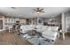 Bright open-concept living room featuring a modern rug, white sofas, and adjacent kitchen area at 3515 N Brooklyn Dr, Buckeye, AZ 85396