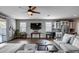 Spacious living room with a ceiling fan, a modern entertainment center, and comfortable seating at 3515 N Brooklyn Dr, Buckeye, AZ 85396