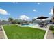Outdoor oasis with a sparkling pool, lush green lawn, and a cozy patio area perfect for relaxation at 3515 N Brooklyn Dr, Buckeye, AZ 85396