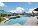 Beautiful backyard pool featuring a stone waterfall, tanning ledge, and travertine tile surround at 3515 N Brooklyn Dr, Buckeye, AZ 85396
