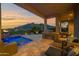 Inviting outdoor patio with pool, outdoor kitchen, lounge chairs, and scenic views at 37221 N Holiday Ln, Carefree, AZ 85377