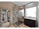 A bathroom with a glass shower, neutral tile work, dark cabinets, and a large decorative mirror at 37221 N Holiday Ln, Carefree, AZ 85377